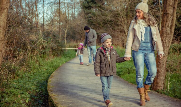 Happy family walking together holding hands in the forest